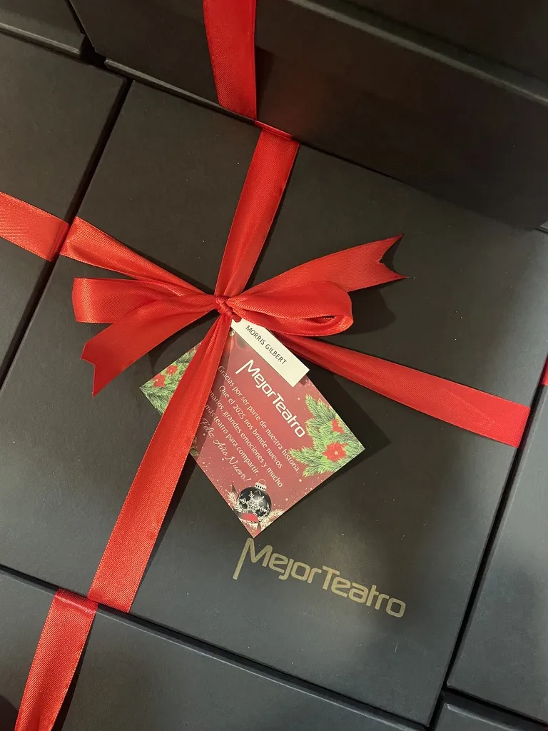 Cajas negras de regalo con moño rojo y tarjeta navideña personalizada para clientes de una empresa